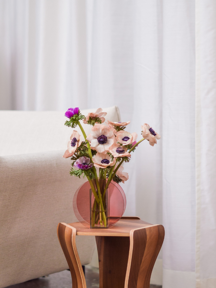 Runde Glasvase in Rosa mit frischem Blumenstrauss.